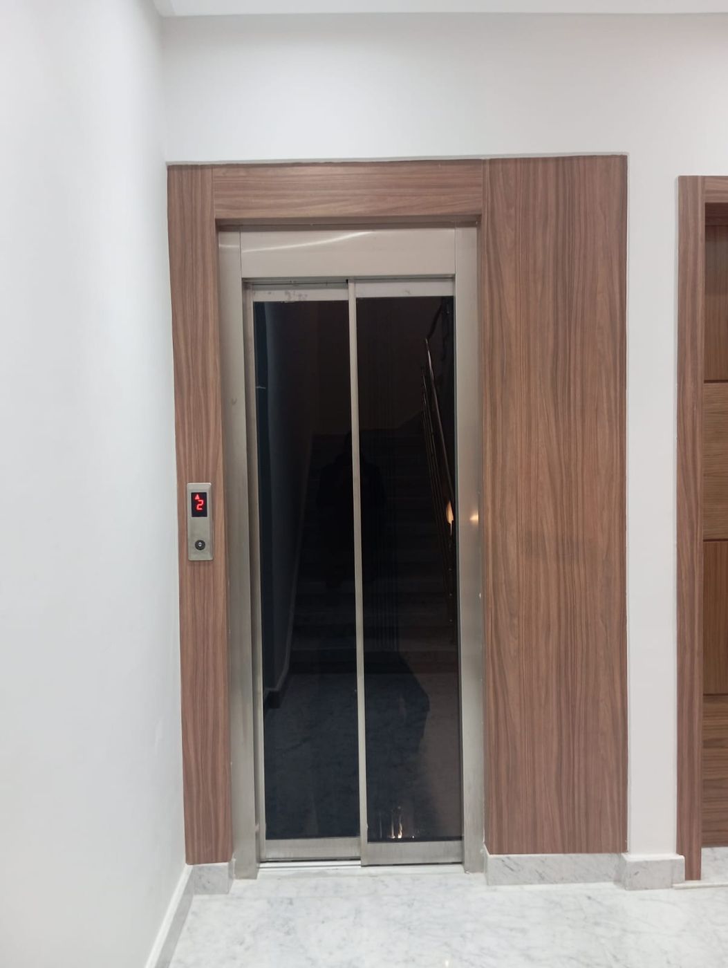 Porte palière encadrée en noyer — réalisation GELCO